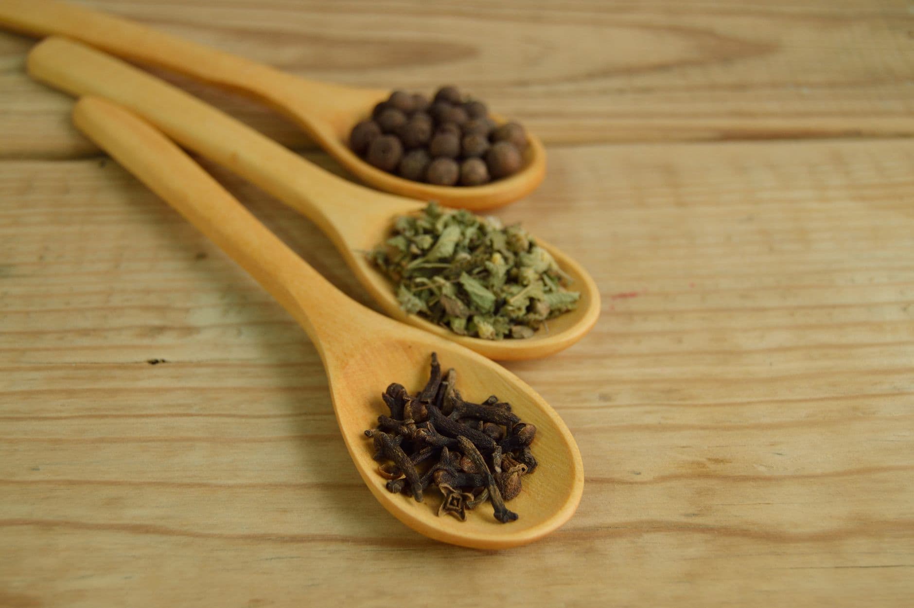 Dried botanical herbs and spices on wooden spoons